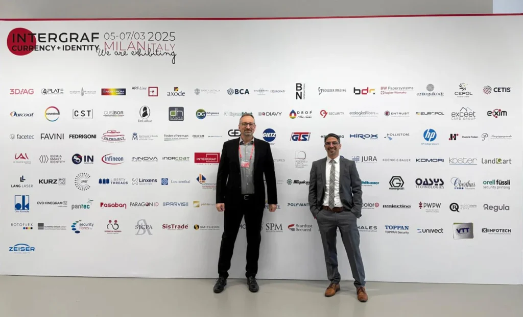 Zwei Mitarbeiter der GTS GmbH vor einer Messewand auf der Intergraf 2025 in Mailand