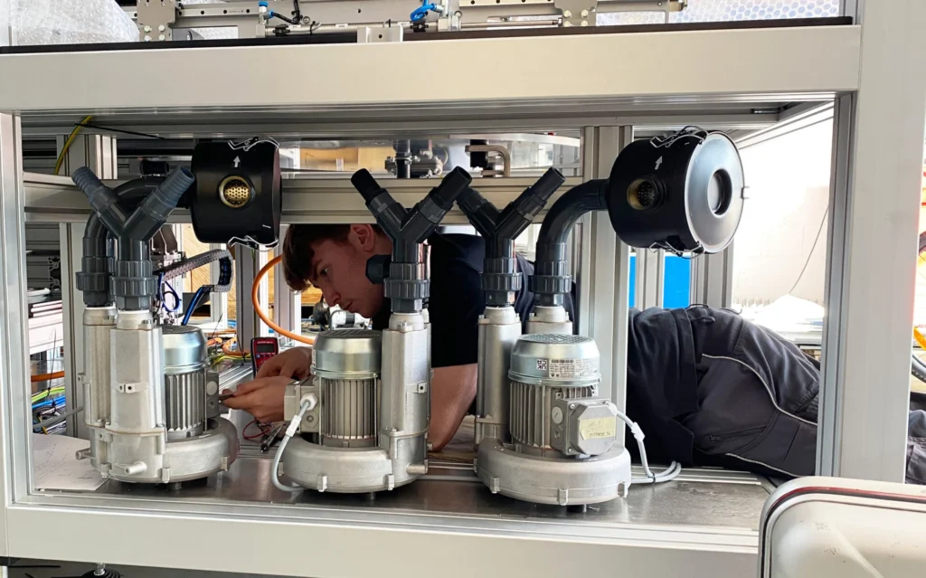 Auszubildender Sebastian führt Arbeiten an einer GTS Countmaster Maschine im Rahmen seiner Ausbildung zum Elektroniker für Betriebstechnik durch.